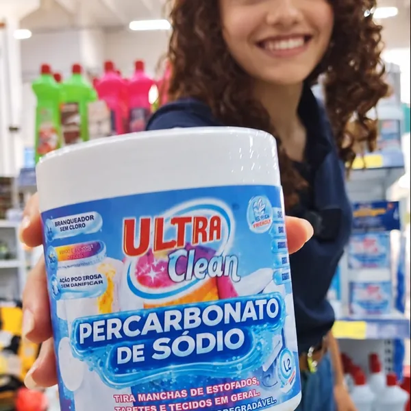 Atendente mostrando produto de limpeza no Armazém Ponto Certo